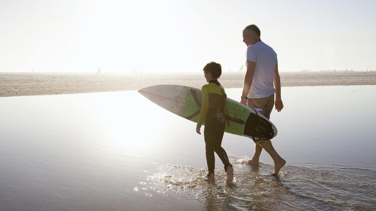 editorial-557921435-man-walking-with-child-on-beach-2880x1620
